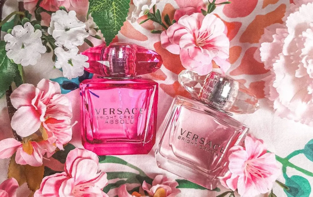 Two bottles of perfume on a floral background.