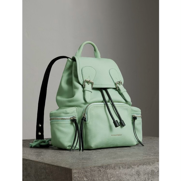 A light green backpack is sitting on top of a table.