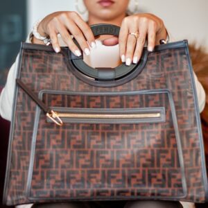 A woman holding a brown fendi runaway shopper bag