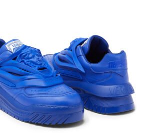 A pair of bright blue medusa versace sneakers