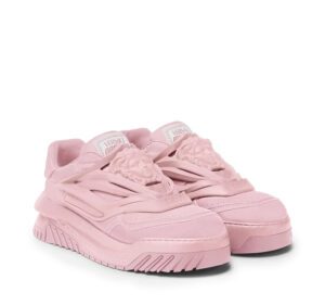 A pair of light pink and white versace sneakers
