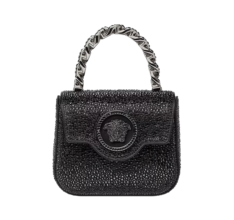 A black purse with a chain handle and medusa head.