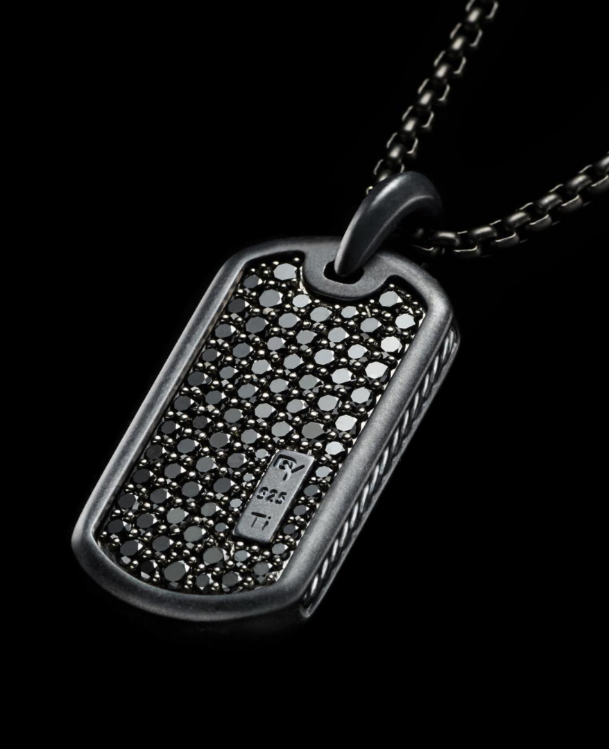 A black dog tag with a chain on it